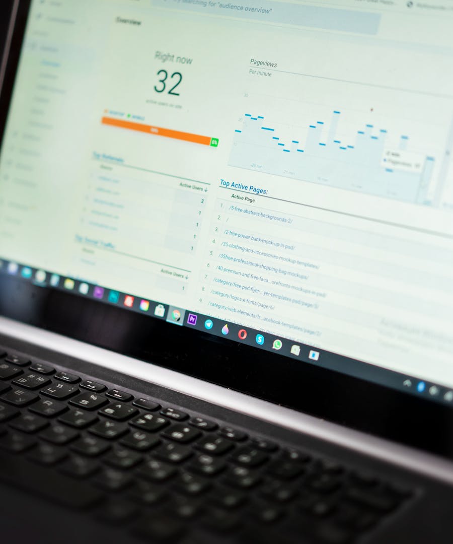 An analytics dashboard open on a laptop screen in a low-lit workspace.
