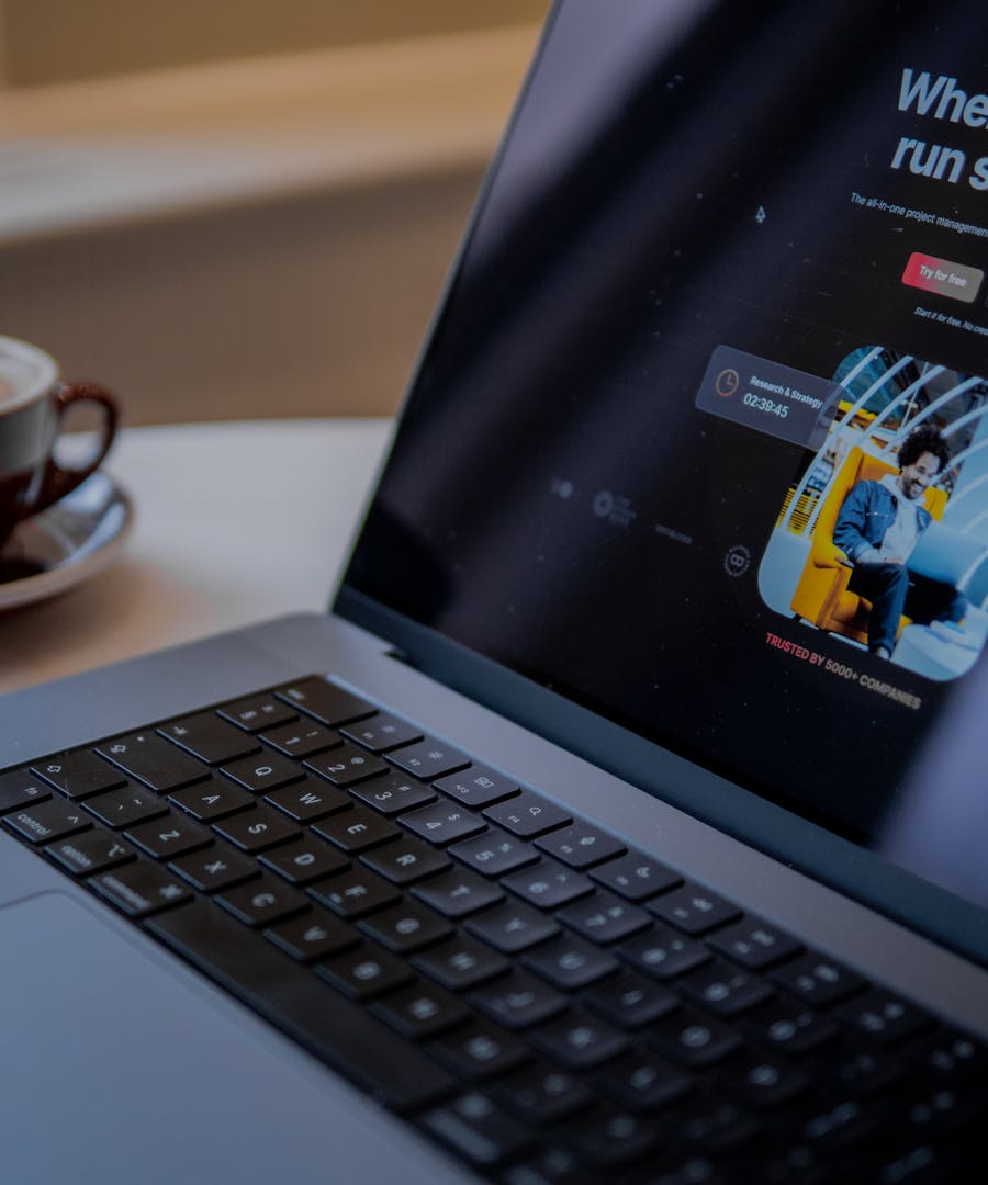 A sleek business website shown on a laptop beside a coffee cup in a calm workspace.